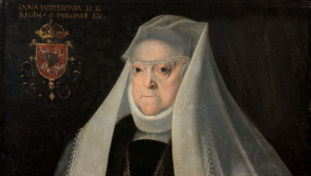 Obraz olejny. Portret królowej Anny Jagiellonki w białym sztywnym welonie na ciemnym tle. W lewym górnym roku jest kartusz herbowy. W lewym dolnym rogu fragment stołu z koroną.